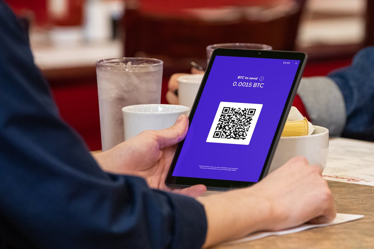 Person scanning QR code on the crypto tablet.
